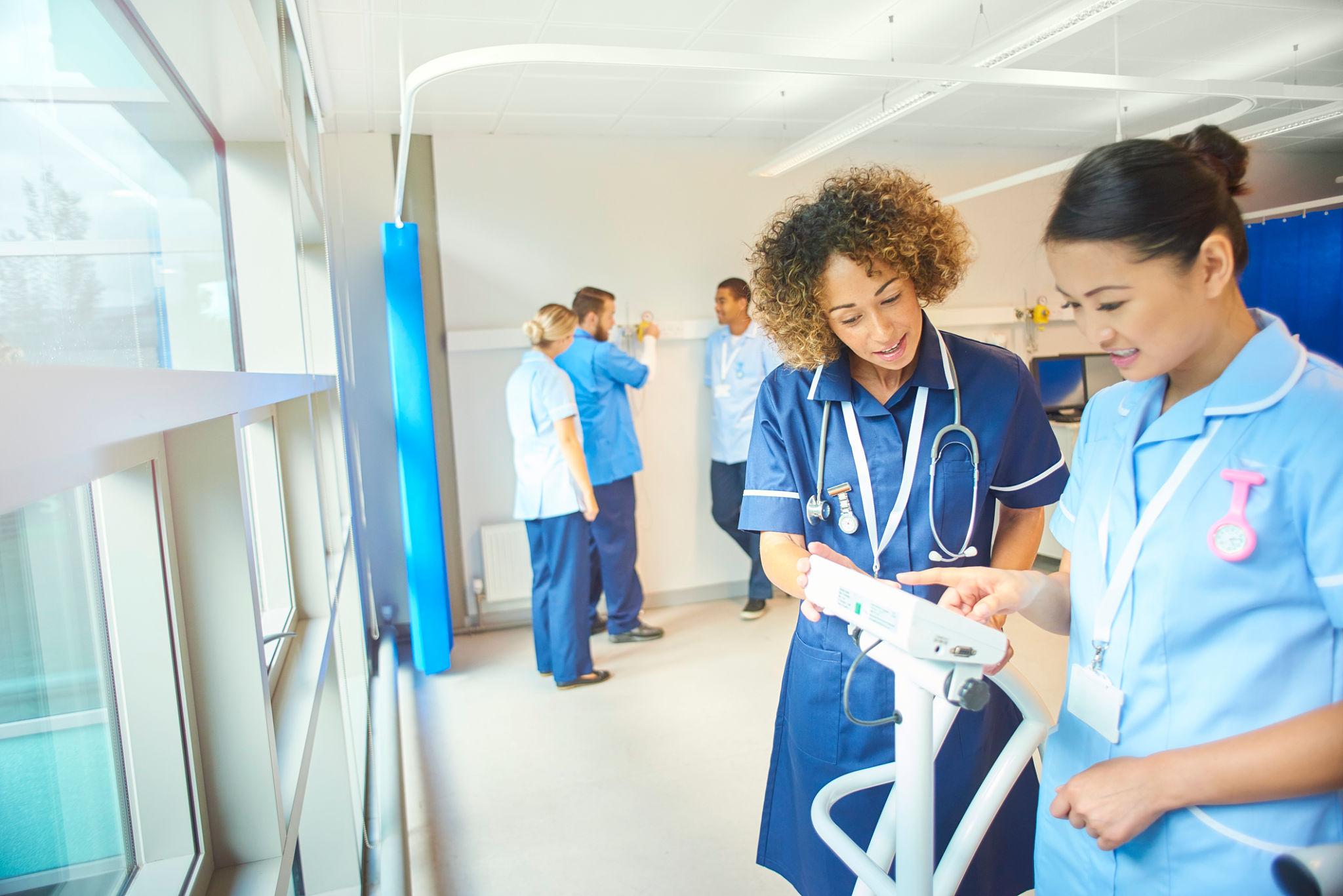 Nursing instructor helping a student during clinical training