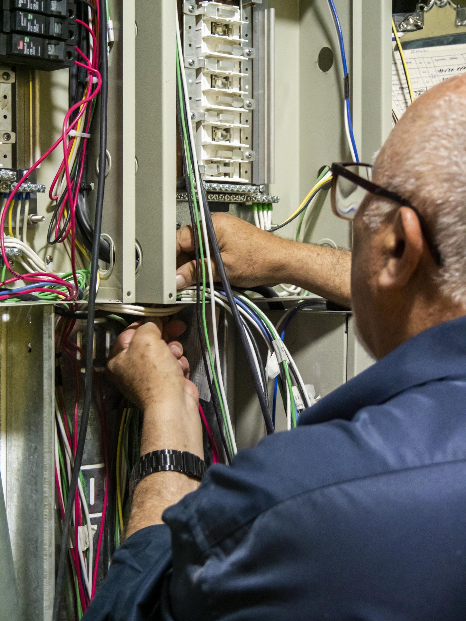 Electrical worker inspecting panel