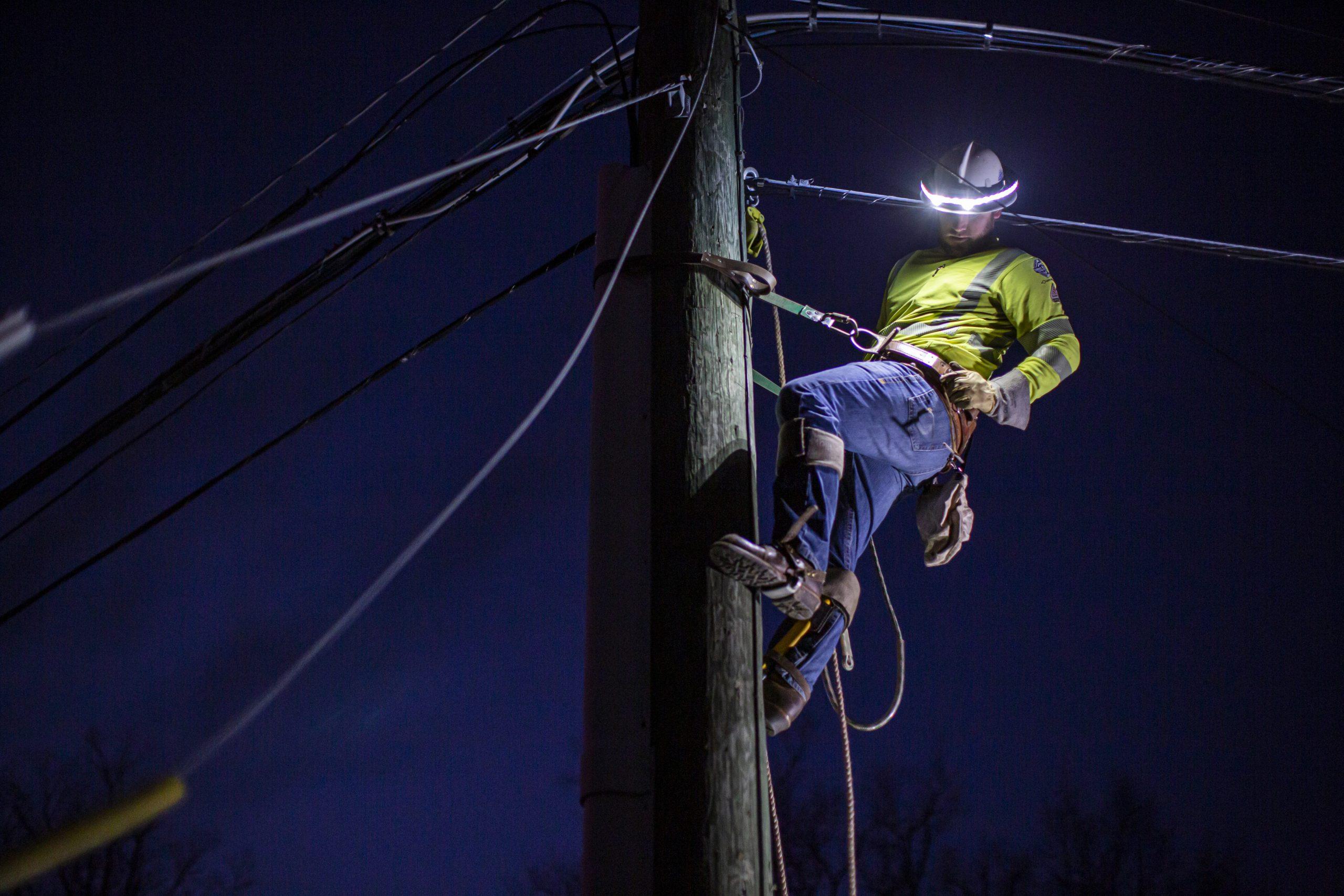 Lineman working at night near power lines