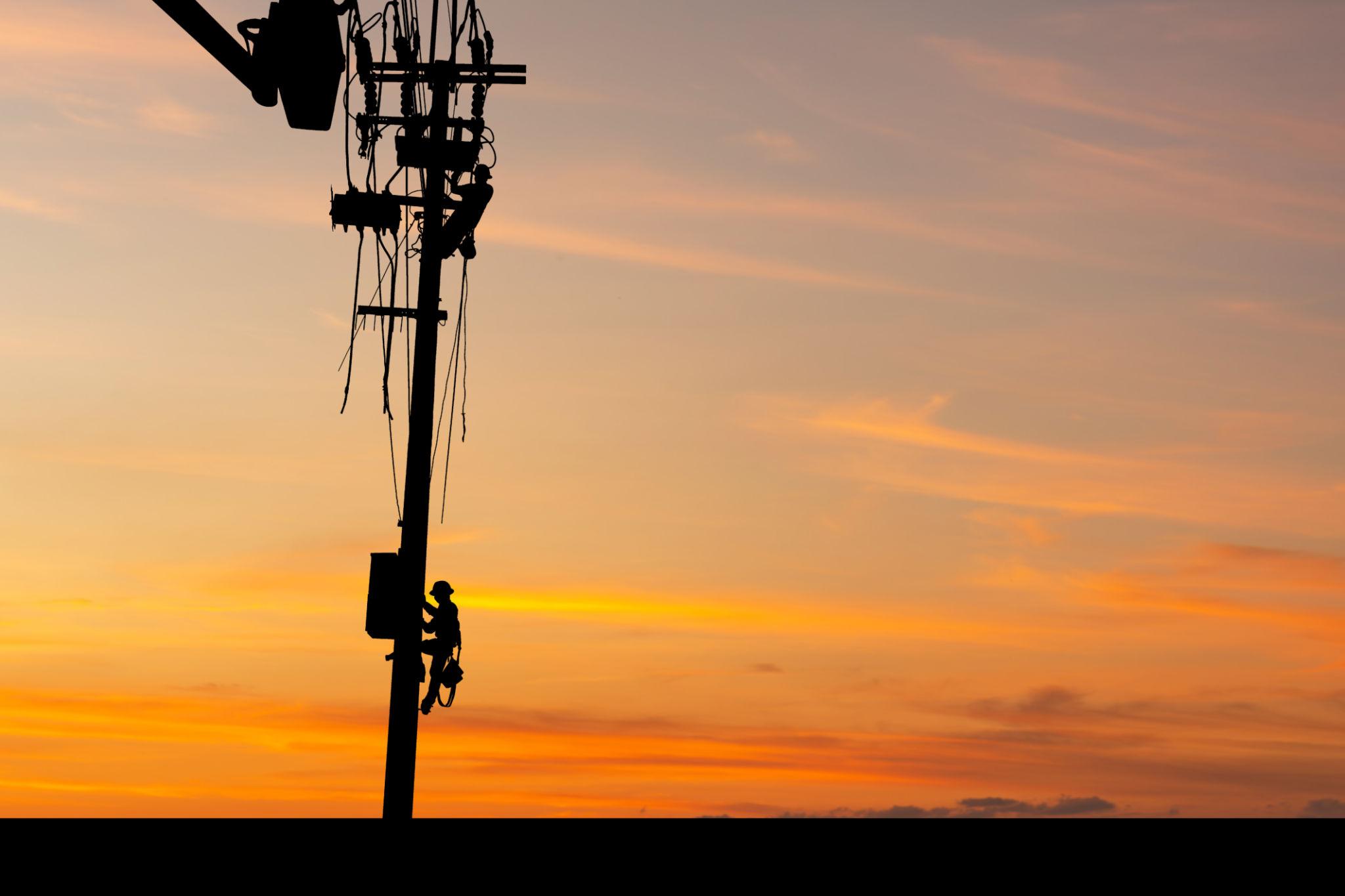 Lineman working at sunrise