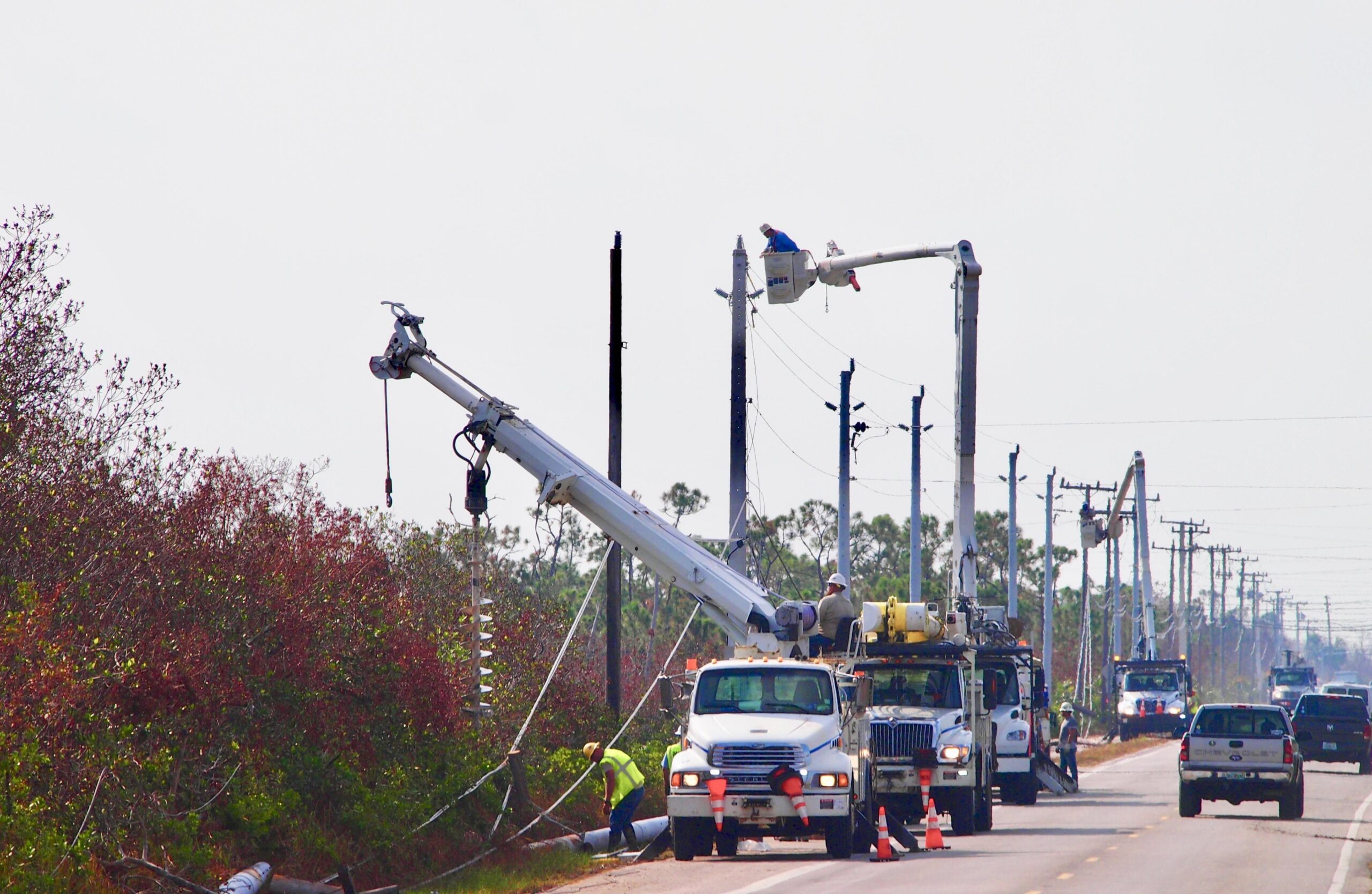 Multiple utility bucket trucks working on power lines